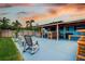 Expansive backyard with a covered patio, outdoor seating, lush green lawn, and mature trees perfect for outdoor living at 13978 Barbados Dr, Seminole, FL 33776