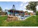 Spacious backyard featuring a covered patio, outdoor seating, brick fire pit, and a manicured lawn perfect for relaxation at 13978 Barbados Dr, Seminole, FL 33776