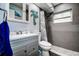 Well-lit bathroom with gray tile surround, modern fixtures, and coastal decor at 13978 Barbados Dr, Seminole, FL 33776