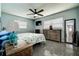 Calm bedroom with ceiling fan, light blue walls, terrazzo floors, natural lighting, and warm wood furniture at 13978 Barbados Dr, Seminole, FL 33776