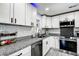 Updated kitchen with granite counters, white subway tile backsplash, stainless appliances, and white cabinets at 13978 Barbados Dr, Seminole, FL 33776
