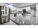 Modern kitchen features granite counters, stainless appliances, white cabinetry, and subway tile backsplash at 13978 Barbados Dr, Seminole, FL 33776
