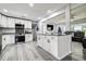 Bright kitchen features white cabinets, stainless steel appliances, stone countertops, and light gray plank flooring at 13978 Barbados Dr, Seminole, FL 33776