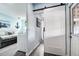 Laundry area showing machines, a slider door, and a comfortable bed with beach themed decorations at 13978 Barbados Dr, Seminole, FL 33776