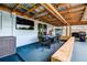 Covered patio featuring an outdoor dining set, barbecue grill and a wooden bench perfect for outdoor gatherings and entertaining at 13978 Barbados Dr, Seminole, FL 33776