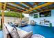 Inviting covered patio with cozy seating, television, and unique corrugated metal ceiling perfect for outdoor relaxation and entertainment at 13978 Barbados Dr, Seminole, FL 33776