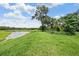 Beautiful backyard view of the lake, lush greenery, and serene landscape at 14063 Wineberry Dr, Dade City, FL 33525