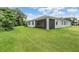 Spacious backyard showcasing lush lawn and partial view of a lake at 14063 Wineberry Dr, Dade City, FL 33525