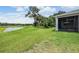 Expansive backyard features mature trees, lush grass, and tranquil lake view at 14063 Wineberry Dr, Dade City, FL 33525