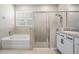 A modern bathroom has a sleek shower, separate bathtub, and vanity at 14063 Wineberry Dr, Dade City, FL 33525