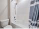 A bathtub and shower features modern finishes with a gray striped curtain at 14063 Wineberry Dr, Dade City, FL 33525