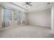 Spacious bedroom with carpet flooring, tray ceiling, and a ceiling fan at 14063 Wineberry Dr, Dade City, FL 33525