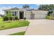 Charming home featuring a manicured lawn, solar panels and a convenient multi-car garage at 14063 Wineberry Dr, Dade City, FL 33525