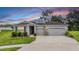 Charming single-story home with a three-car garage, solar panels, and lush landscaping at 14063 Wineberry Dr, Dade City, FL 33525