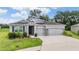 Charming home featuring a manicured lawn, solar panels and a convenient multi-car garage at 14063 Wineberry Dr, Dade City, FL 33525