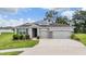 Beautiful home featuring a manicured lawn, solar panels and a convenient multi-car garage at 14063 Wineberry Dr, Dade City, FL 33525