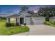 Charming single-story home featuring a well-manicured lawn, solar panels, and a spacious two-car garage at 14063 Wineberry Dr, Dade City, FL 33525