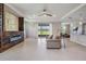 Spacious living room with a modern fireplace, neutral tones, and sliding glass doors to backyard at 14063 Wineberry Dr, Dade City, FL 33525