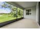 Screened-in patio showcases serene views of the lush backyard, trees, and lake at 14063 Wineberry Dr, Dade City, FL 33525