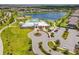 Aerial shot of community center with pool, playground, and parking, nestled by a serene lake at 14206 Covert Green Pl, Riverview, FL 33579