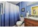 Well-lit bathroom with a blue wall and a combination shower and tub, complemented by a vanity with granite countertop at 14206 Covert Green Pl, Riverview, FL 33579