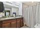 Bathroom with a double sink vanity with decorative countertop and a shower with curtain at 14206 Covert Green Pl, Riverview, FL 33579