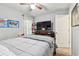 Bright bedroom features neutral tones, a ceiling fan, and a dresser with a large screen TV for a comfortable retreat at 14206 Covert Green Pl, Riverview, FL 33579