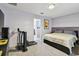 Bedroom with lilac colored walls, carpet, a treadmill, bed, and entrance to the bathroom at 14206 Covert Green Pl, Riverview, FL 33579