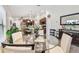 Bright dining area features a glass table, with modern white chairs, and an open-concept layout to the kitchen at 14206 Covert Green Pl, Riverview, FL 33579