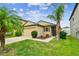 Attractive front yard with lush lawn, mature palm trees and a two-car garage at 14206 Covert Green Pl, Riverview, FL 33579