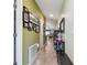 Bright hallway with tiled floor, multiple framed photos, and views into the dining room at 14206 Covert Green Pl, Riverview, FL 33579