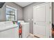Laundry room with washer, dryer, window, door, and some supplies at 14206 Covert Green Pl, Riverview, FL 33579