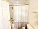Bathroom featuring a tub/shower combo, toilet, and tiled walls at 1427 Hillview Ln, Tarpon Springs, FL 34689
