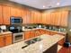 Bright kitchen features stainless steel appliances, wood cabinets and granite countertops at 1427 Hillview Ln, Tarpon Springs, FL 34689