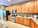 Bright kitchen features stainless steel appliances, wood cabinets and granite countertops at 1427 Hillview Ln, Tarpon Springs, FL 34689