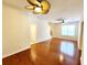 Hardwood floors and a ceiling fan adorn this light-filled living room, leading to the stairway and a dining area at 1427 Hillview Ln, Tarpon Springs, FL 34689