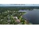 Stunning aerial view of lakefront property with lush landscaping and downtown Tampa skyline in the distance at 14808 Lake Magdalene Cir, Tampa, FL 33613