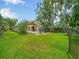 Spacious backyard view with a wooden deck, manicured lawn, and fenced perimeter at 14808 Lake Magdalene Cir, Tampa, FL 33613