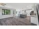 Open-concept kitchen featuring a large island, stainless steel appliances, and sleek, grey wood flooring at 14808 Lake Magdalene Cir, Tampa, FL 33613