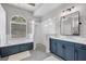 Well-lit bathroom featuring a modern glass shower, soaking tub, and dual sink vanity at 15309 Palomapark Ln, Lithia, FL 33547