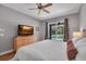 Bright bedroom with a large bed, TV, ceiling fan, and sliding glass doors leading to the pool at 15309 Palomapark Ln, Lithia, FL 33547