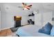Bright bedroom with a ceiling fan, TV, and a workspace, offering comfort and functionality at 15309 Palomapark Ln, Lithia, FL 33547