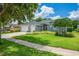 Charming single-story home with well-manicured lawn, mature trees, and a two-car garage at 15309 Palomapark Ln, Lithia, FL 33547