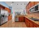 A modern kitchen features wood cabinets, mosaic backsplash, stainless appliances and granite countertops at 15309 Palomapark Ln, Lithia, FL 33547