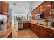 Well-equipped kitchen featuring granite countertops, stainless steel appliances, and cherry wood cabinetry at 15309 Palomapark Ln, Lithia, FL 33547