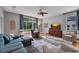 Cozy living room features large windows, hardwood flooring, ceiling fan, and comfortable furniture at 15309 Palomapark Ln, Lithia, FL 33547