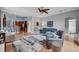 An open-concept living room featuring hardwood floors, large windows, and seamless access to the kitchen at 15309 Palomapark Ln, Lithia, FL 33547