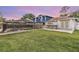 Large backyard featuring a pool, outdoor kitchen, and well-maintained lawn, perfect for relaxing at 15609 Gardenside Ln, Tampa, FL 33624