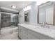 Modern bathroom with double vanity, marble countertop, and tiled walk-in shower at 15609 Gardenside Ln, Tampa, FL 33624