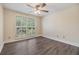 Bright bedroom featuring wood-look flooring, ceiling fan and a big window at 15609 Gardenside Ln, Tampa, FL 33624